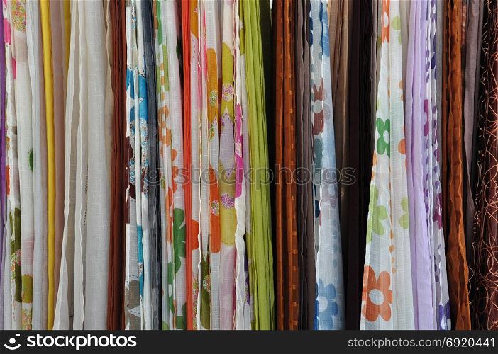 Colorful textiles for sale at street market. Abstract fabric background.