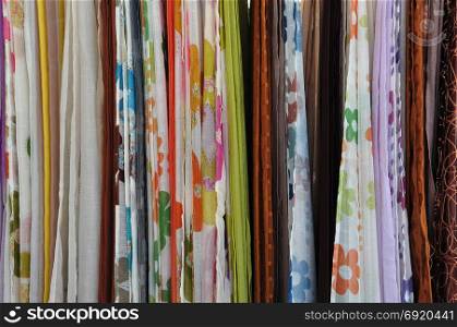 Colorful textiles for sale at street market. Abstract fabric background.