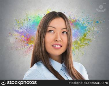 Colorful Thinking. Business woman against gray background and colorful splashes