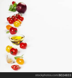 colorful tomatoes and vegetables over white background - Healthy eating, vegetarian or cooking concept