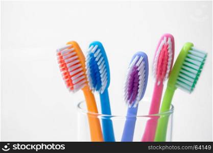 colorful toothbrushes in glass