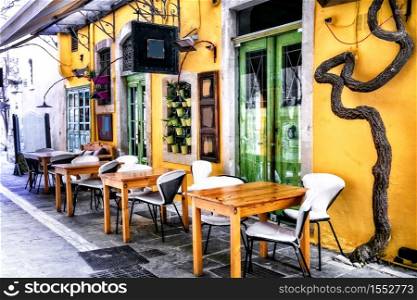 Colorful traditional Greece series - small street restaurants (taverns) in old town of Rethymno, Crete island. traditional tavern in narrow streets of old town Rethymno, Crete island, Greece