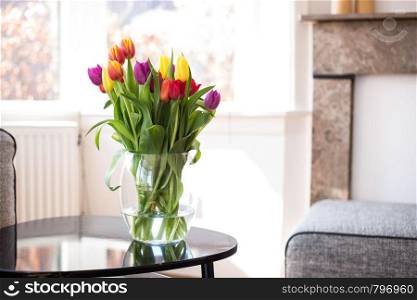 Colorful tulip flowers, various colors on table in the livingroom, April concept on light background. Colorful tulip flowers, various colors on table in the livingroom, April concept