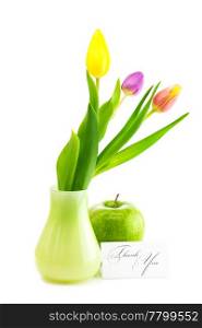colorful tulips in vase,apple and a card signed thank you isolated on white