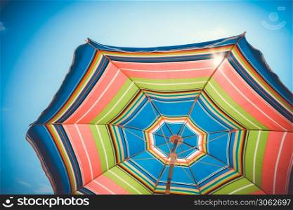 Colorful umbrella close-up view on blue sky. Colorful umbrella close-up view