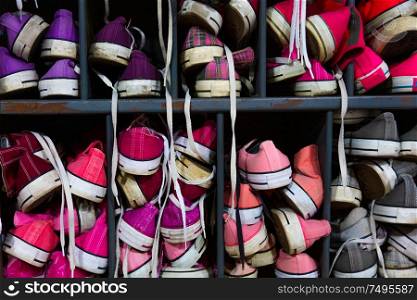 Colorful used high top trainers, plimsoles or training shoes in a locker room or a second hand thrift store or charity shop