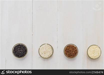 colorful variety rice bowls arranged as border wooden background