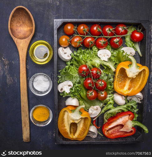 Colorful various of organic farm vegetables in a wooden box with wooden spoon on wooden rustic background top view close up