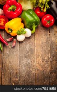 Colorful vegetables over old wooden table