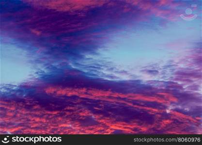 Colorful vibrant clouds on sky at sunset. Romantic and dramatic cloud formation on dusk sky. blue and purple cold landscape with sunlight.