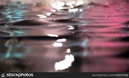 Colorful water surface with changing color. Beautiful calm background.