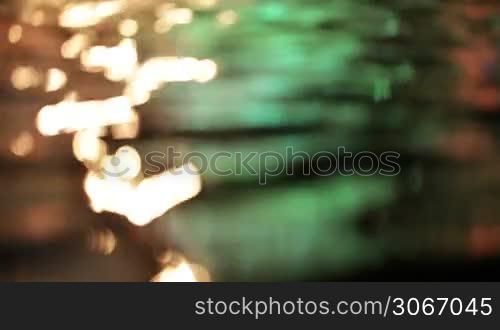 Colorful water surface with changing color. Focus turning.