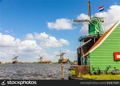 Colorful Windmills with Duthc flags at the river Zaan, Zaanse Schans, Zaandam, The Netherlands