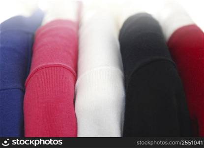 Colorful women&acute;s sweaters on a rack on padded hangers
