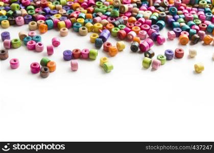 Colorful wooden beads scattered on white background with sample text