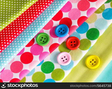 Colorful wooden buttons on the textiles, sew concept