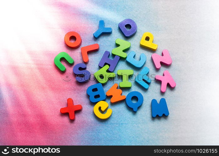 Colorful wooden letters scattered on a white background