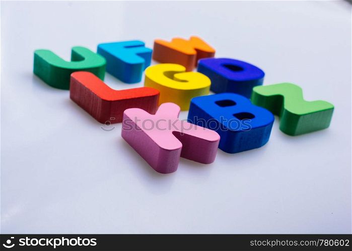 Colorful wooden letters scattered on a white background