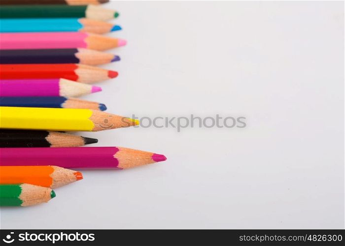 Colorful wooden pencils on a white paper