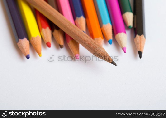 Colorful wooden pencils on a white paper