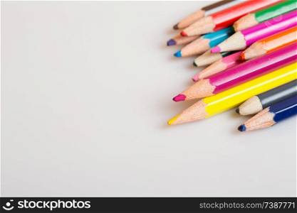 Colorful wooden pencils on a white paper