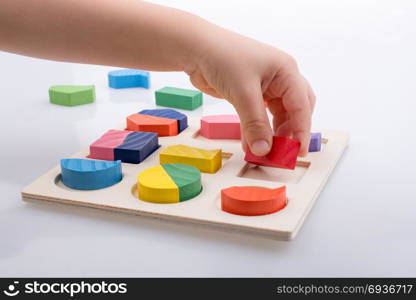 Colorful wooden pieces of a logic puzzle in hand