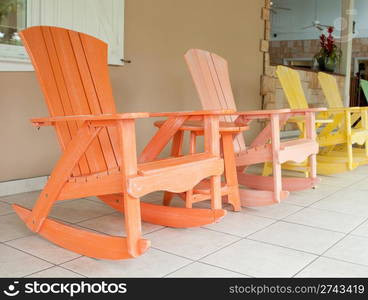 colorful wooden rocking chairs on a porch (usual setting on a tropical resort)