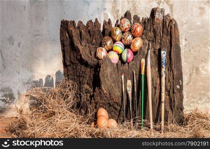 Colorfull easter egg,painted brush and hay with old brown log