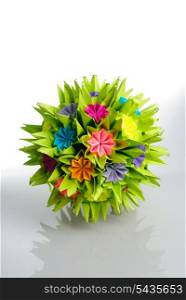 Colorfull origami kusudama from rainbow flowers isolated on white. Thorns and roses