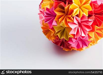 Colorfull origami kusudama from rainbow flowers on white. Warm colours