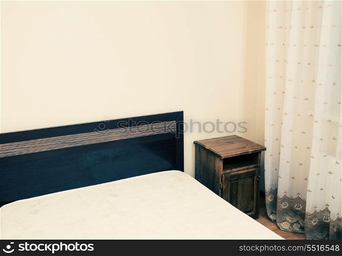 Colorized image of a part of a room with bed in a corner
