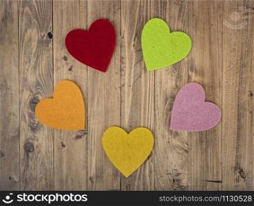 coloured hearts forming a circle on a walnut wood background. Concept of St. Valentine&rsquo;s Day