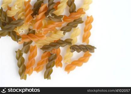 coloured pasta spirals over a light background