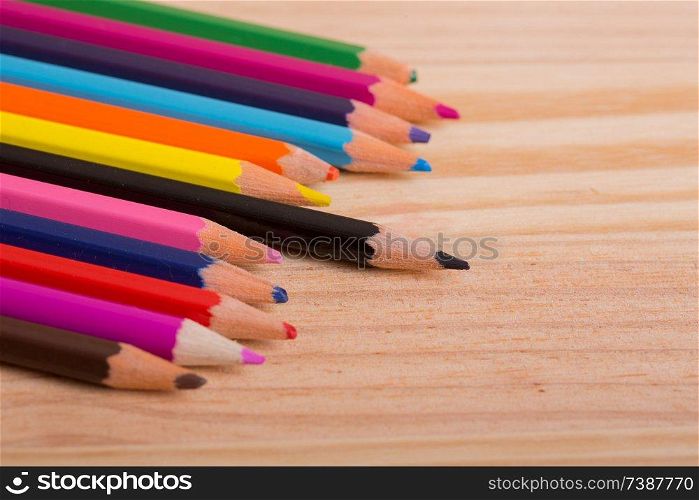 coloured pencils on the wooden background