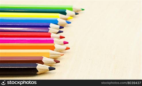 coloured short pencils on wood background