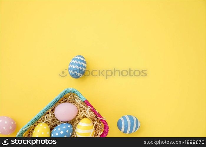 colourful easter eggs small basket yellow table. Resolution and high quality beautiful photo. colourful easter eggs small basket yellow table. High quality beautiful photo concept