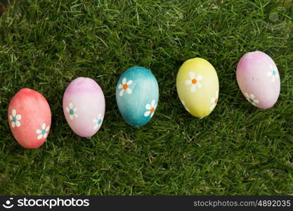 Colourful Easter Eggs with flowers painted placed on the grass