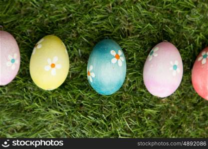 Colourful Easter Eggs with flowers painted placed on the grass