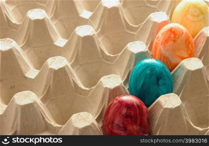 Colourful eggs in carton