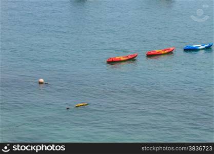 Colourful kayaks floating on tropical sea