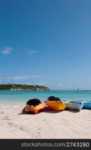 colourful kayaks on a white sandy beach, Long Bay in Antigua (blue sky background)