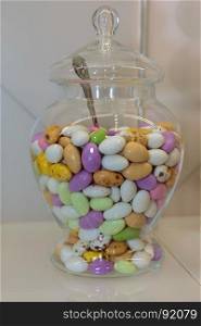 Colourful Sugared Almond inside Glass Jars on White Shelf