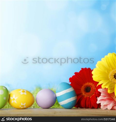 Colourful traditional Easter eggs arranged with colourful Gerbera daisies