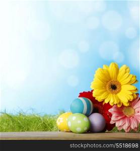 Colourful traditional Easter eggs arranged with colourful Gerbera daisies