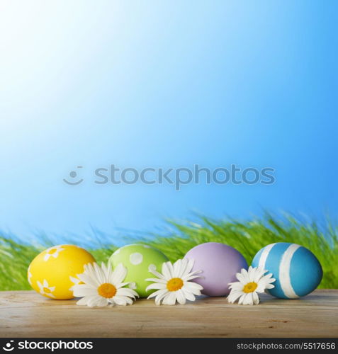 Colourful traditional Easter eggs arranged with daisies