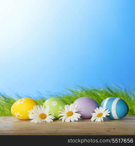 Colourful traditional Easter eggs arranged with daisies