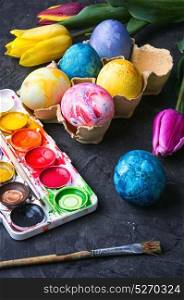 colouring eggs for eastertime. Multicolored easter eggs, set of watercolors and tulips