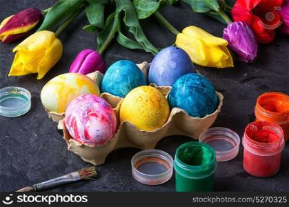 colouring eggs for eastertime. Multicolored easter eggs, set of watercolors and tulips.Happy easter