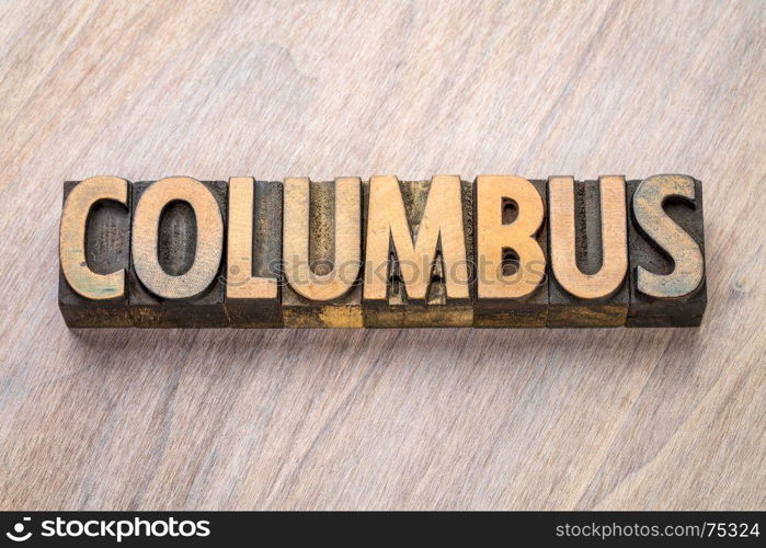 Columbus word abstract in vintage letterpress wood type against grained wooden background