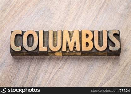 Columbus word abstract in vintage letterpress wood type against grained wooden background